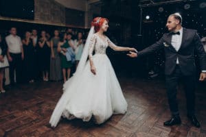 happy bride and stylish groom dancing at wedding reception. gorgeous wedding couple performing first dance in restaurant. newlyweds, emotional moment. space for text.