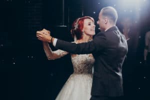 happy bride and stylish groom dancing at wedding reception. gorgeous wedding couple performing first dance in restaurant. newlyweds, emotional moment. space for text.